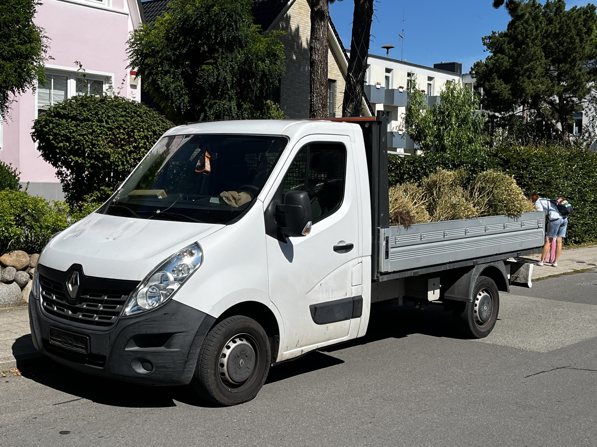 Weißer Pritschenwagen mit Ladefläche am Straßenrand